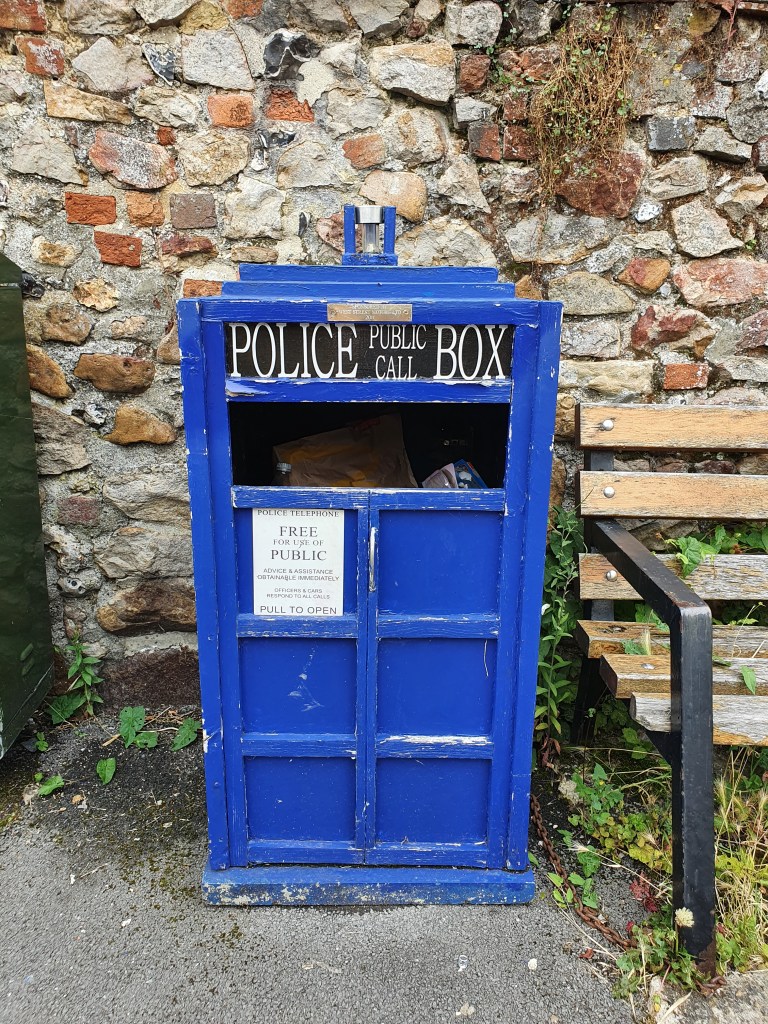 Blue, TARDIS shaped rubbish bin by a bench